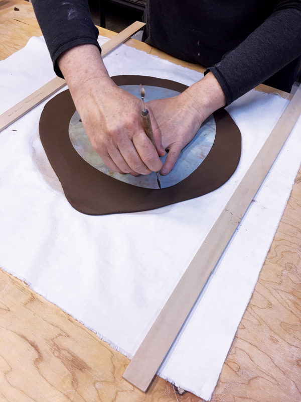 2 Use an old plastic place mat to create a template, then place it on top of the slab and cut out the shape for the saucer.