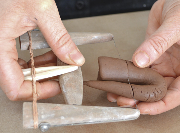 8 Using a handmade miniature bow tool, slice off the excess clay at an angle that corresponds to the side of the cup.