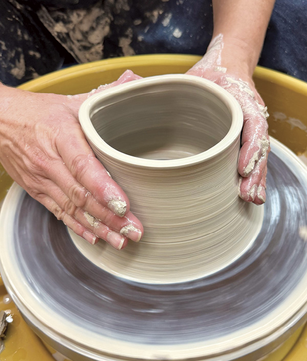 5 Use both hands to shape the thrown form and persuade it into a noticeable cylinder shape.