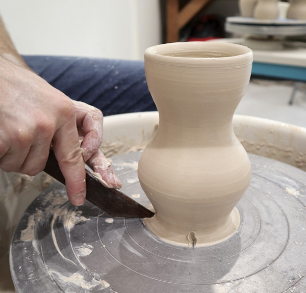 3 Visually divide and mark the foot of the cylinder into quarters with a wooden knife.