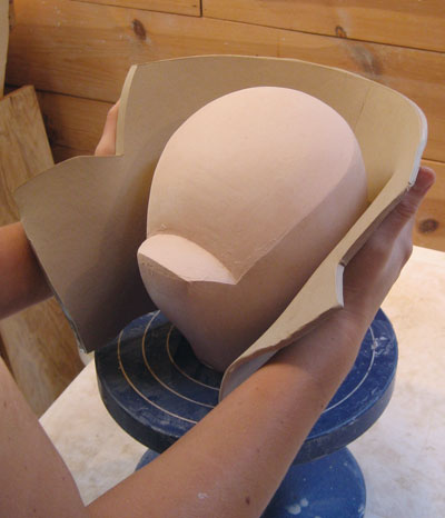 7. Right after cutting the shape, wrap the cut slab around the bisque mold.