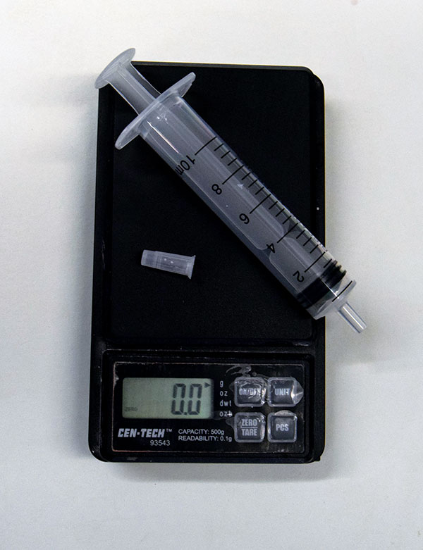 1 Zero out the scale with the empty syringe resting on it. 