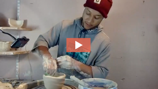 Image of Dwayne Sackey stretching a faceted mug on the pottery wheel.