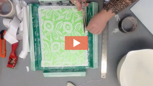 Image of Sam Briegel trimming a piece of fabric for a plaster mold.